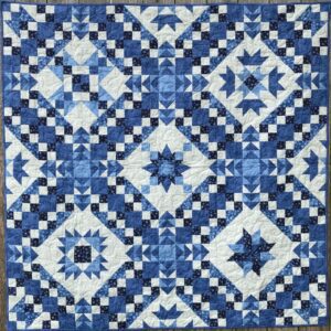 A blue and white quilt with different designs.