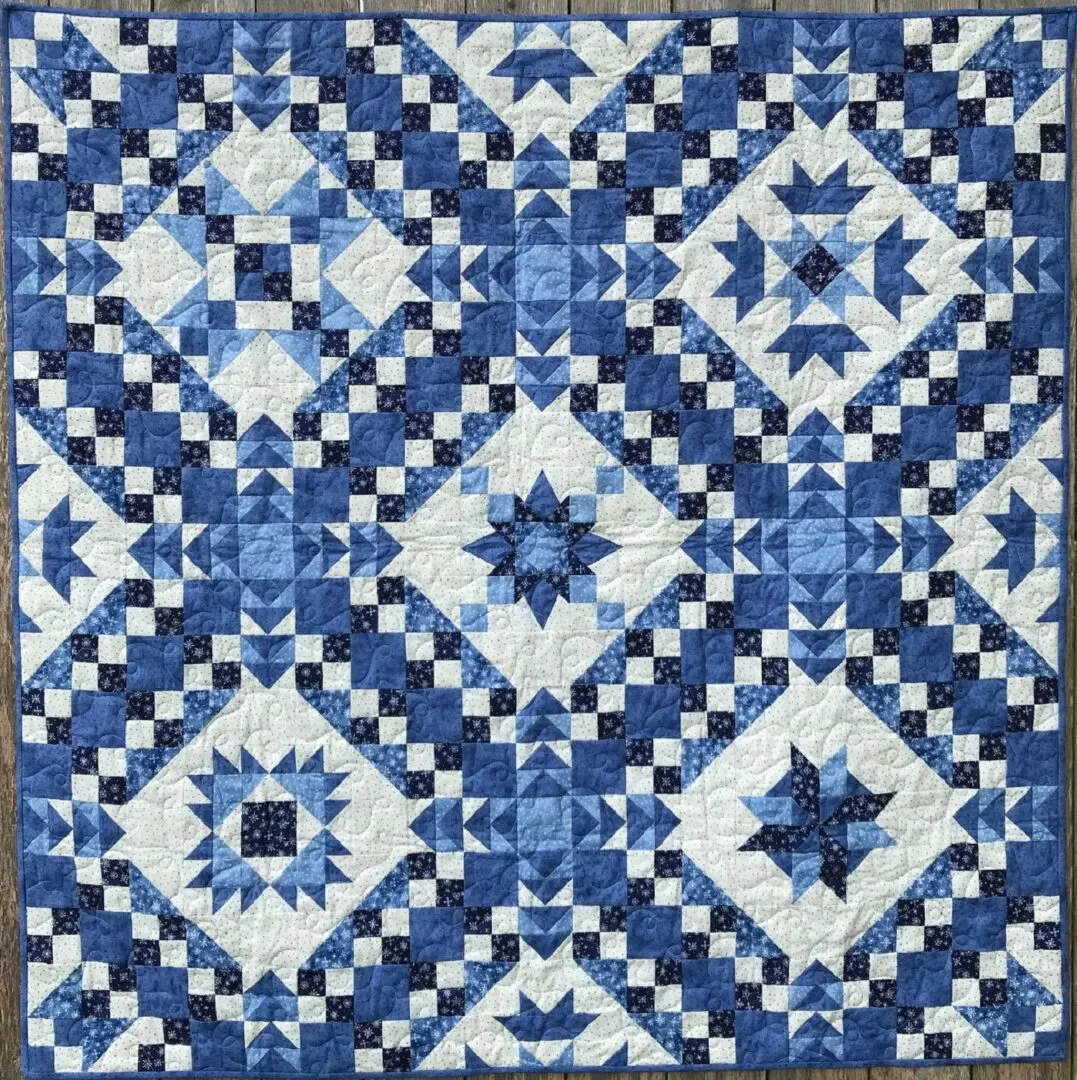 A blue and white quilt with different designs.