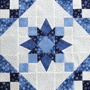 A blue and white quilt with a star design.