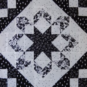A black and white quilt with a star design.