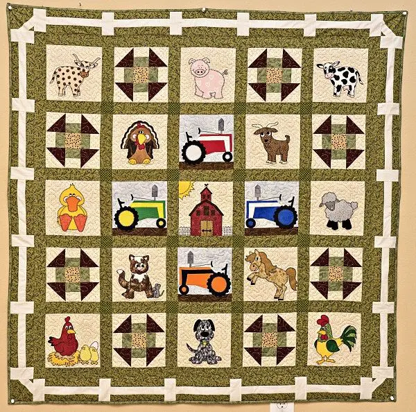 A quilt with farm animals and tractors on it.