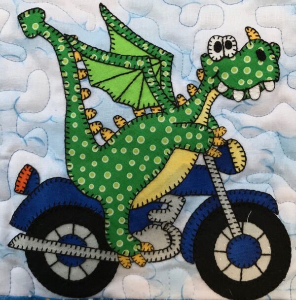 A green dragon on a motorcycle with polka dots.