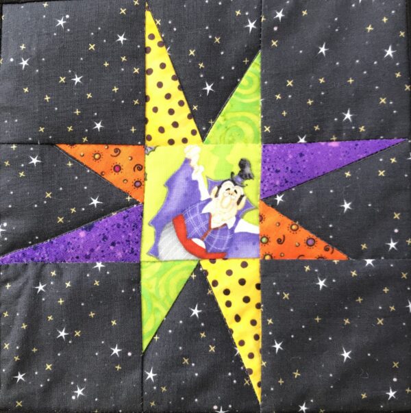 A quilt with a star and the word " witchy ".