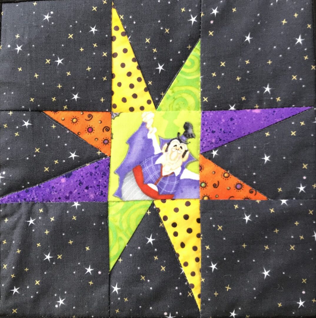 A quilt with a star and the word " witchy ".