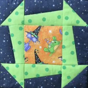 A green and black quilt with witches on it