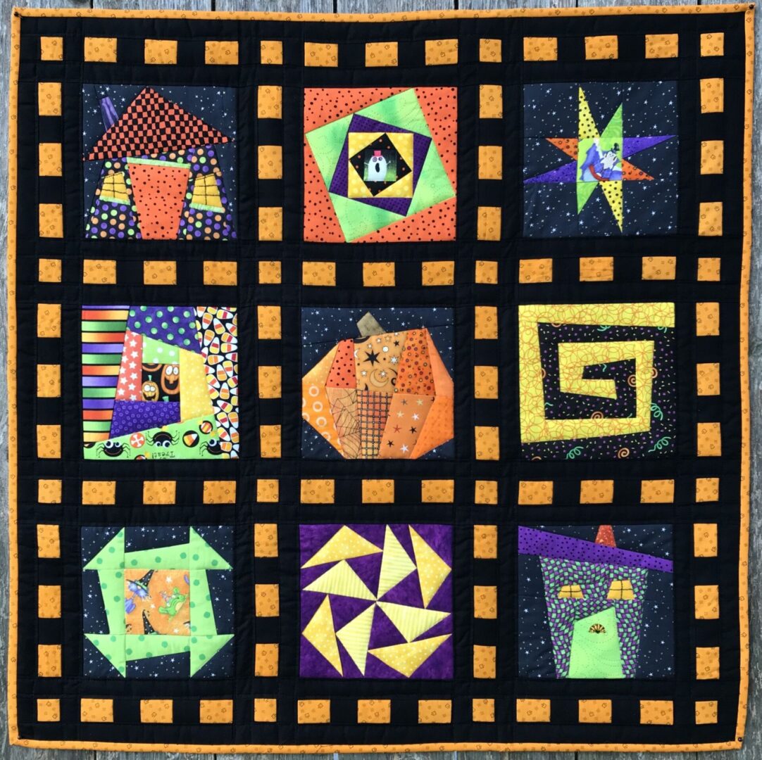 A quilt with nine different designs on it.