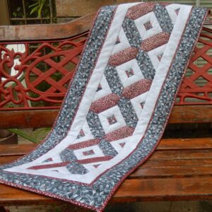 A table runner is sitting on the bench.