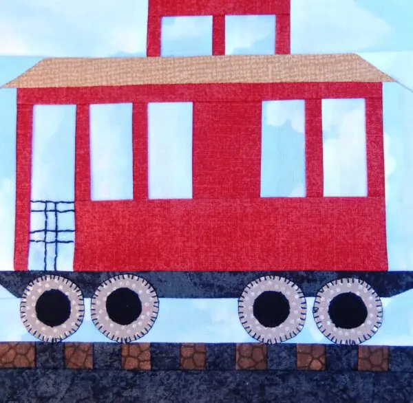 A red caboose is on the tracks.