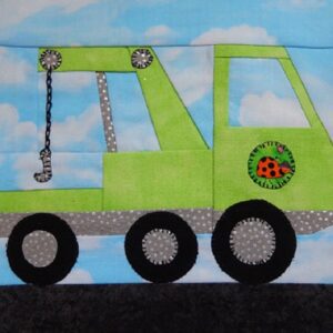 A green tow truck with chains on the side.