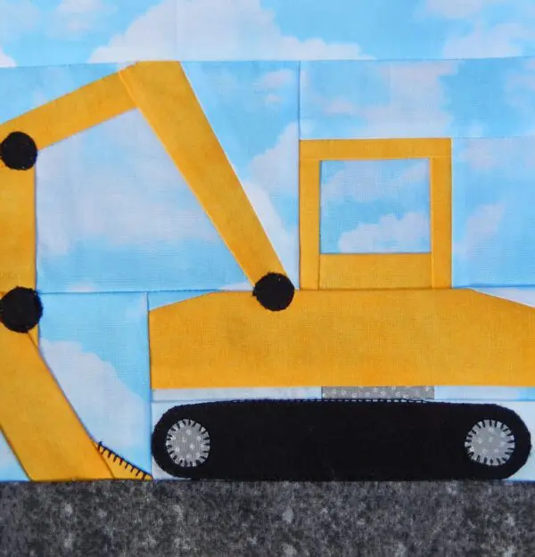 A yellow and black construction truck on top of a blue sky.