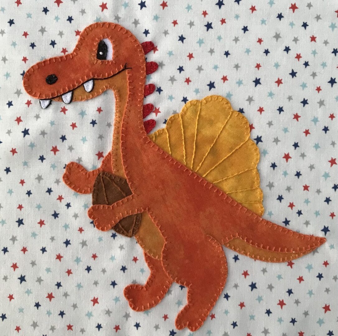 A red and yellow dinosaur on top of a white polka dot background.