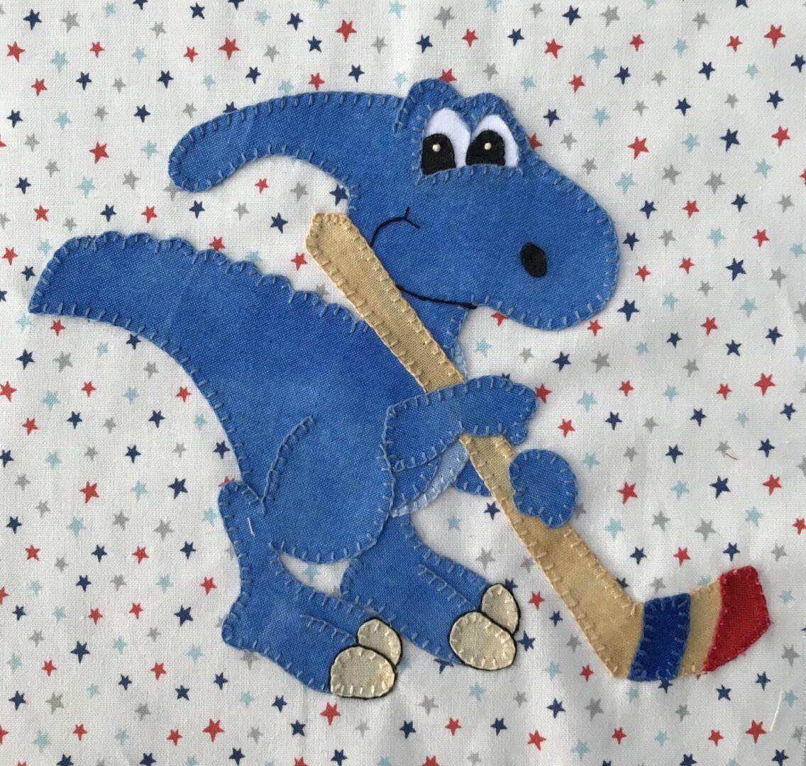 A blue dinosaur holding a stick in its mouth.