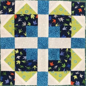 A quilt with blue and green squares on it.