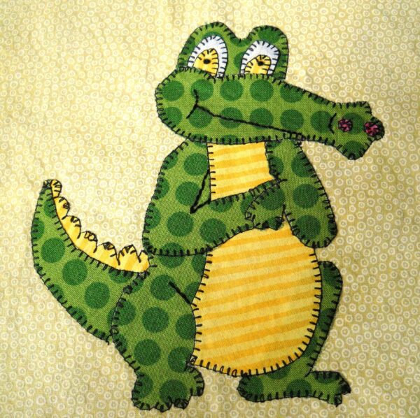 A green and yellow alligator is on the towel.