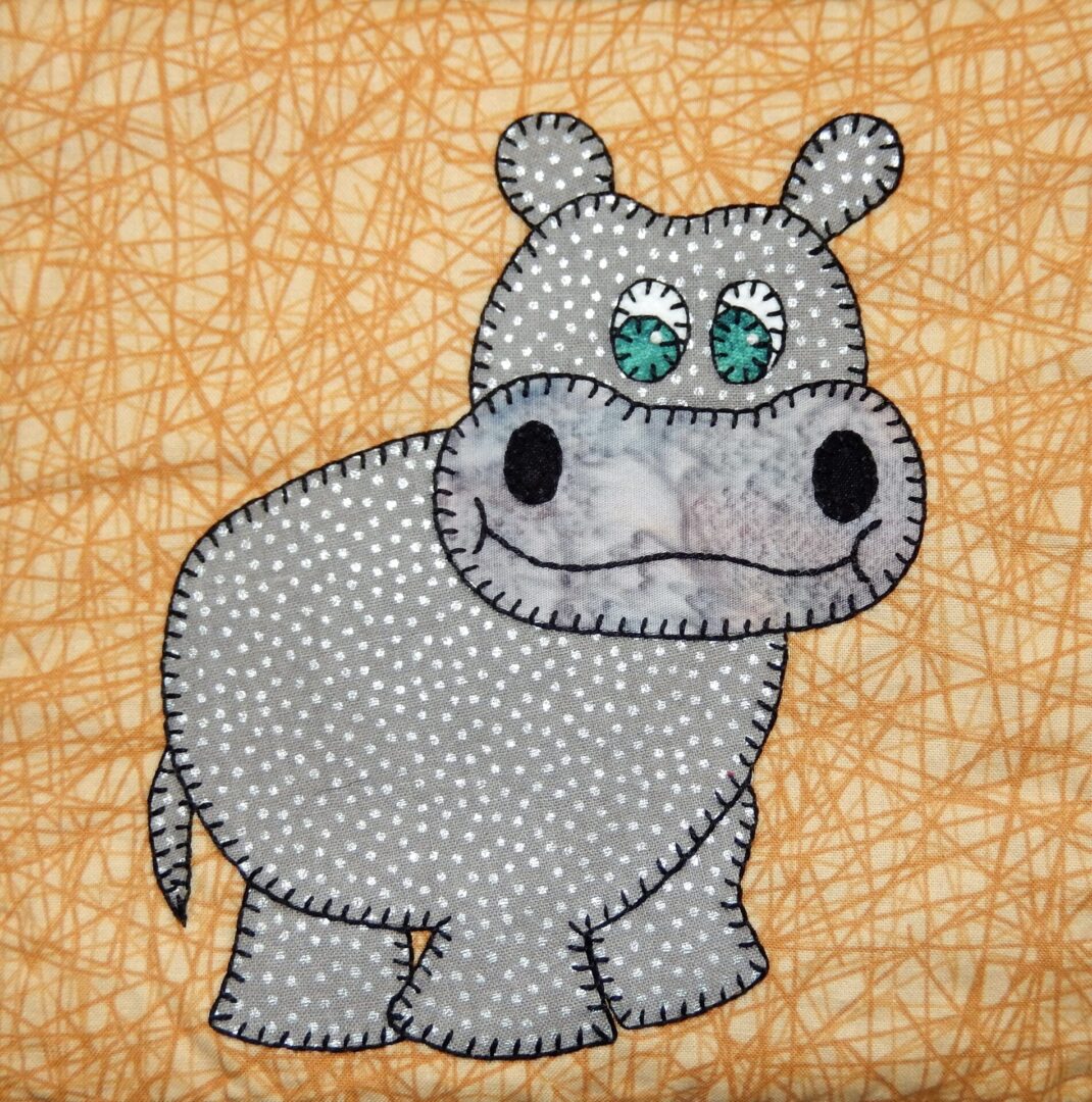 A Hippopotamus appliqued on a brown background.