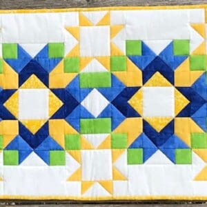 A table runner with blue, yellow and green designs.