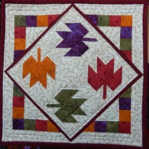 A quilt with four leaves on it.