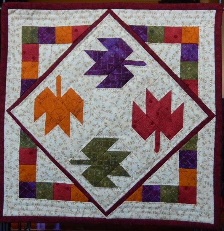 A quilt with four leaves on it.