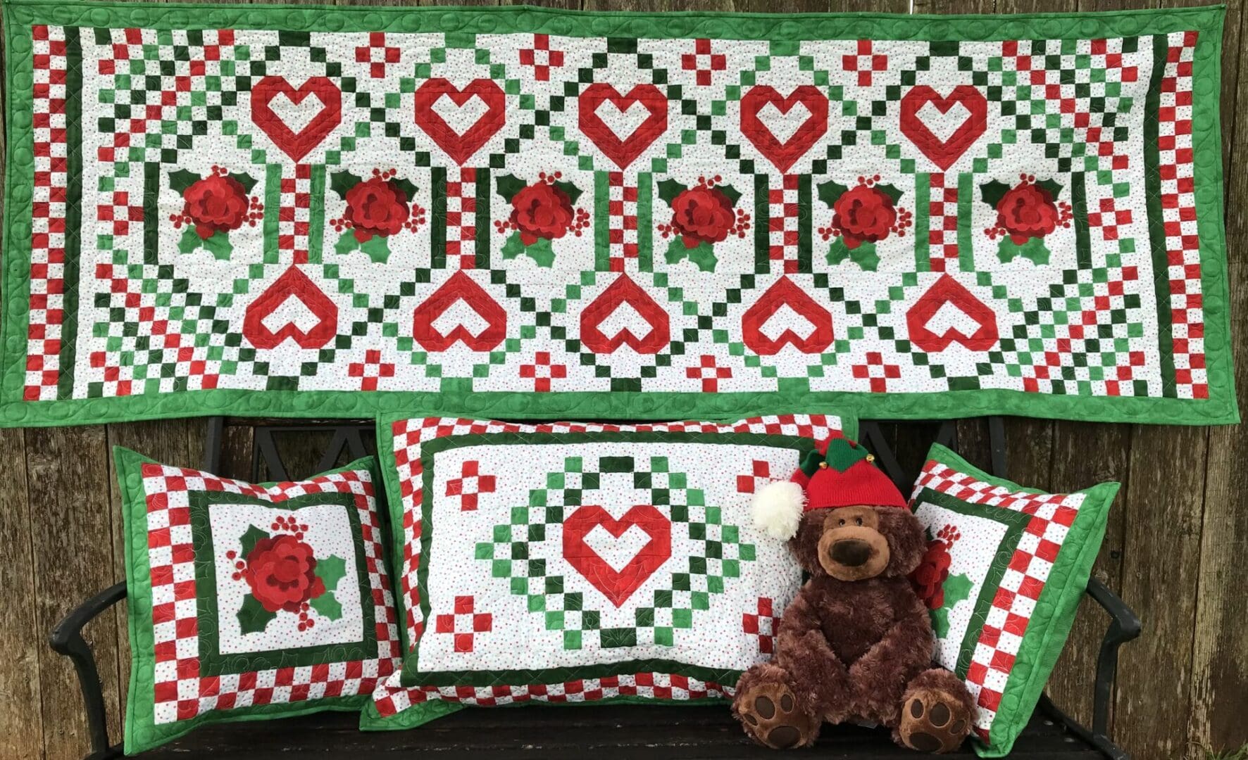 A teddy bear sitting next to a quilt.