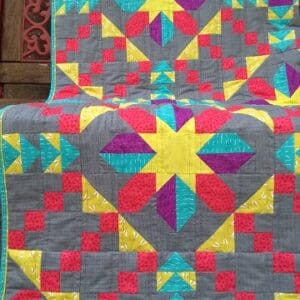 A colorful quilt is sitting on the floor.