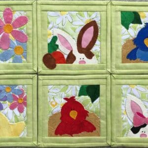 A group of six square quilted coasters with different designs.