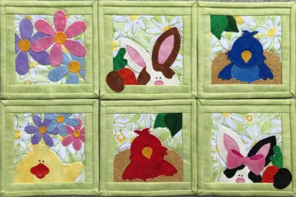 A group of six square quilted coasters with different designs.