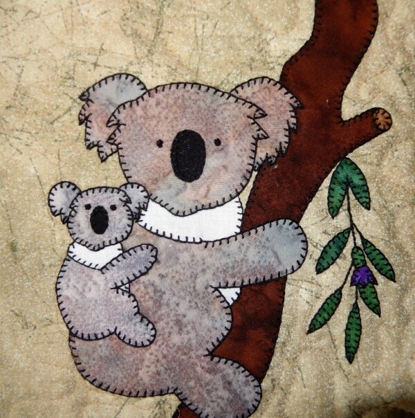 A koala bear and baby koala are on the tree.