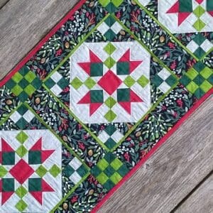 A table runner with red, green and white designs.