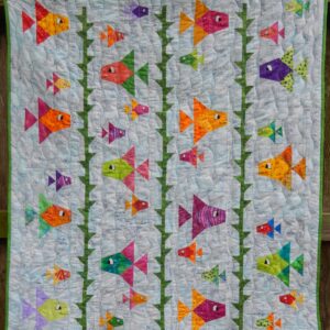 A quilt with colorful fish on it.