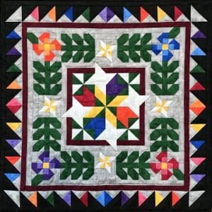 A quilt with colorful flowers and leaves on it.