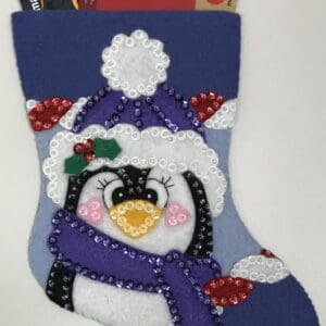 A penguin stocking with purple and white trim.