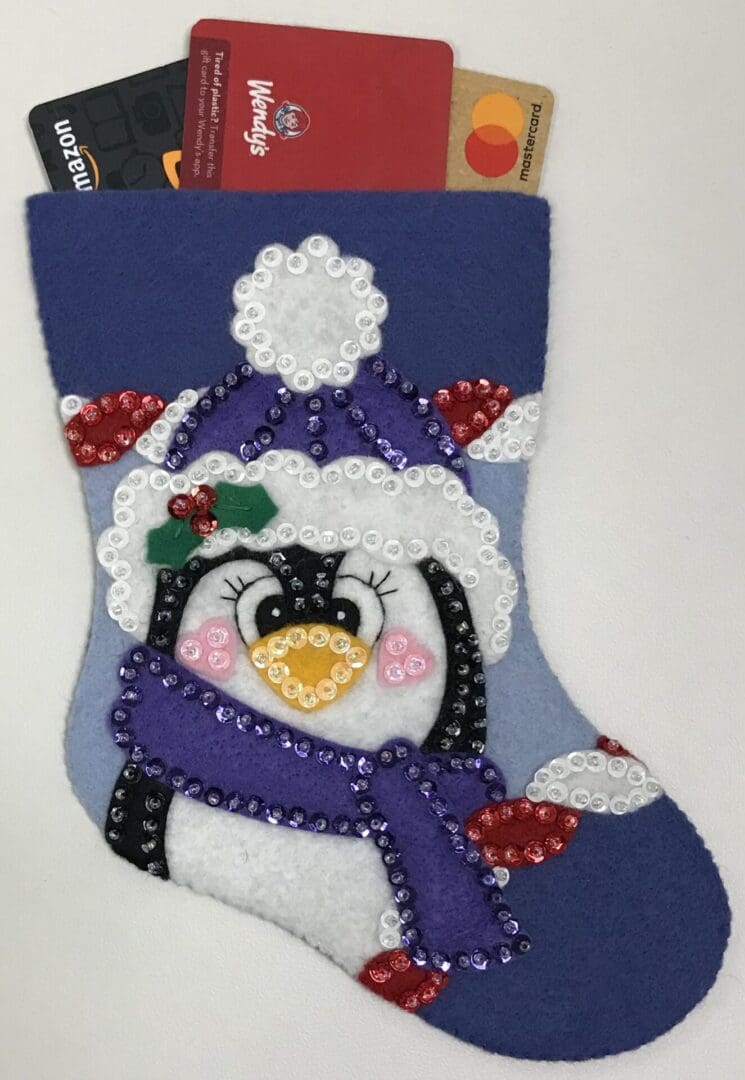 A penguin stocking with purple and white trim.