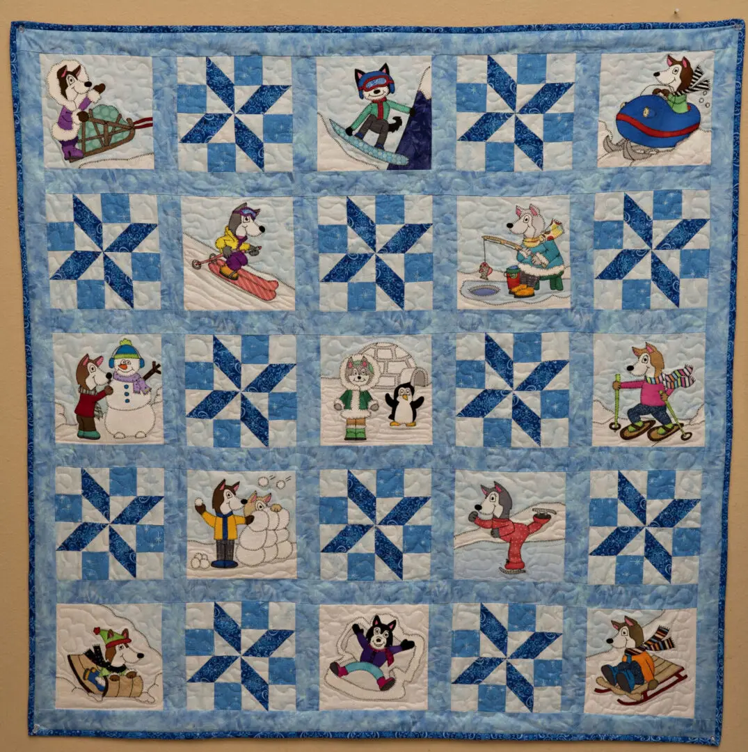 A quilt with cats and dogs on it.