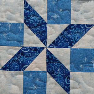 A blue and white quilt with a star pattern.