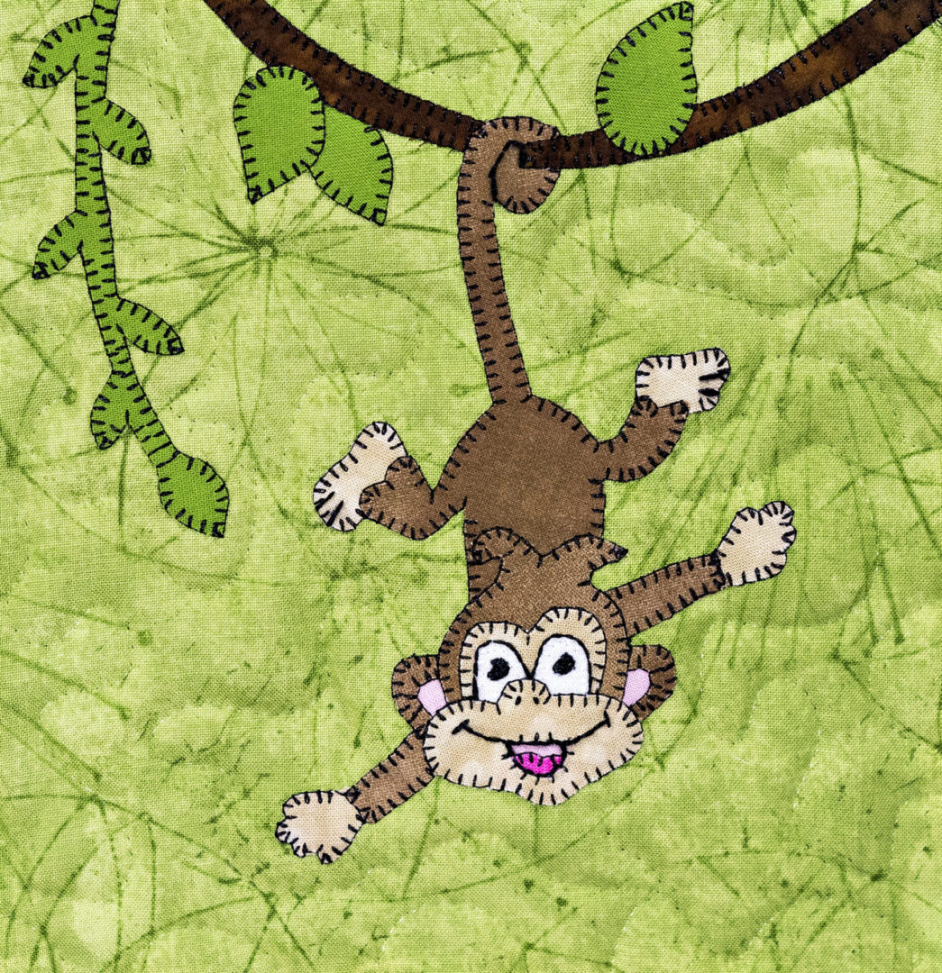 A monkey hanging from the tree limb of a branch.