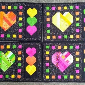 A set of four heart coasters with different colors.