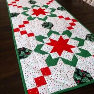 A table runner with red, green and white designs.