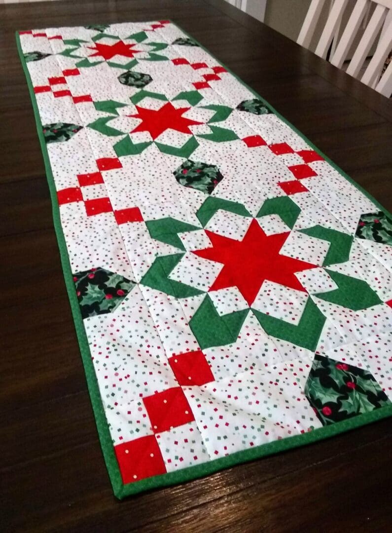 A table runner with red, green and white designs.