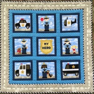 A quilt with police and fire fighters on it.