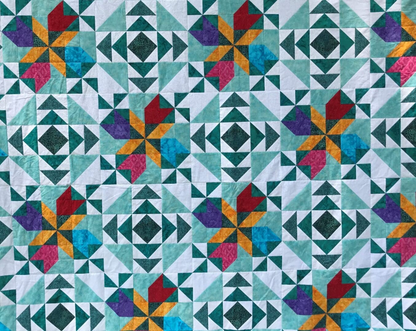 A quilt with different colored designs on it.
