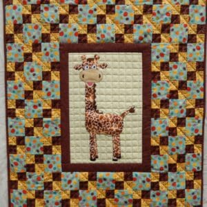 A giraffe quilt with a brown frame around it.