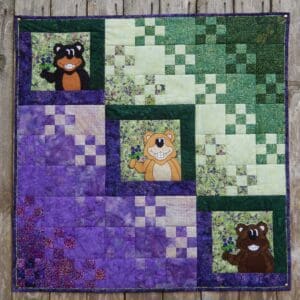 A quilt with squares and bears on it.