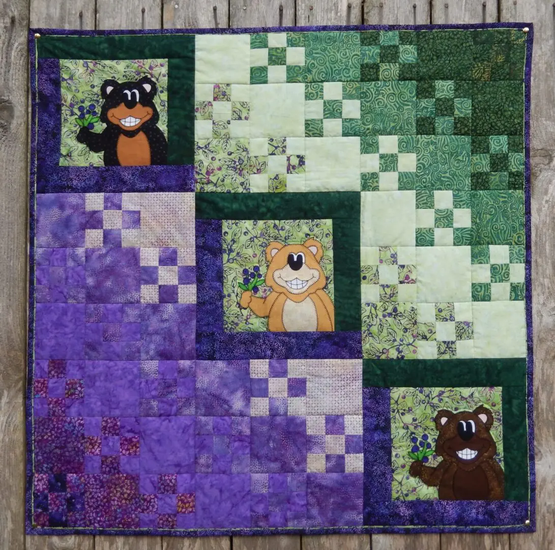A quilt with squares and bears on it.