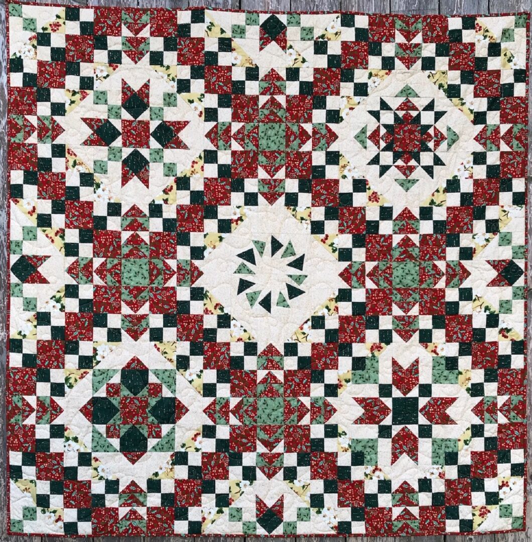 A quilt with red, white and green designs.