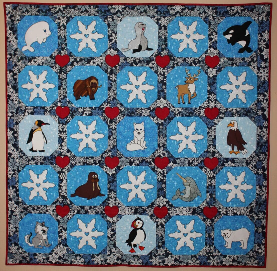 A quilt with different animals and snowflakes on it.