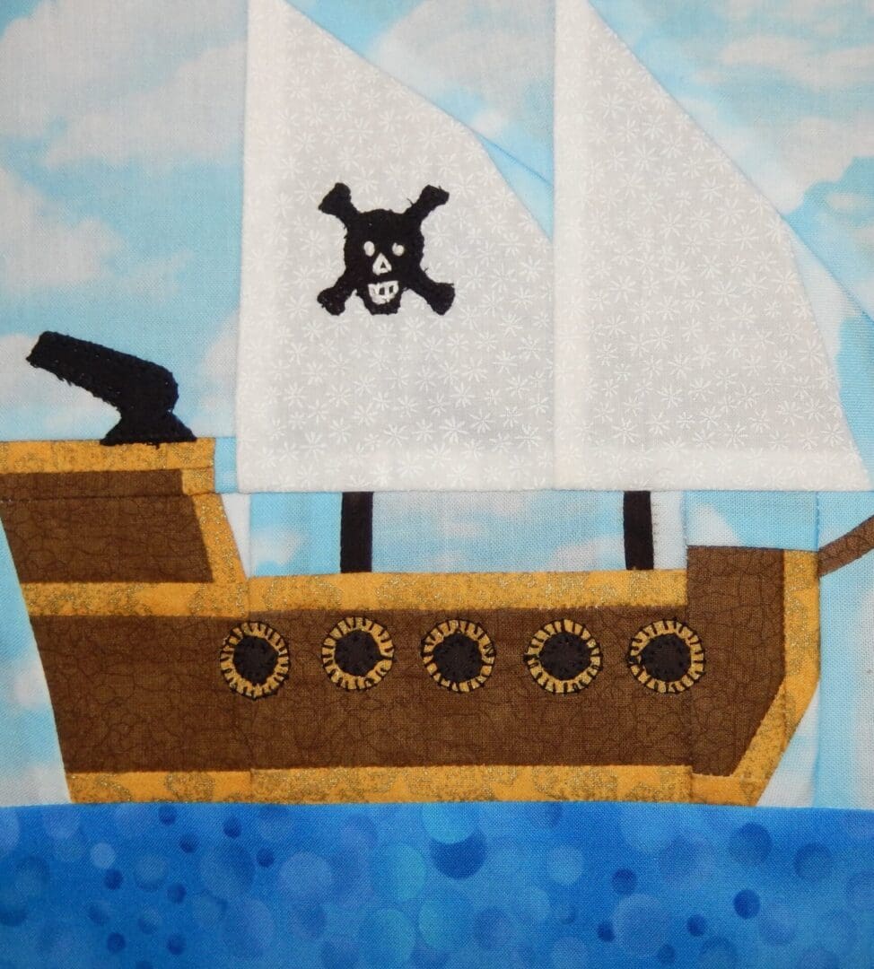 A pirate ship quilt block with a skull and crossbones on the sail.