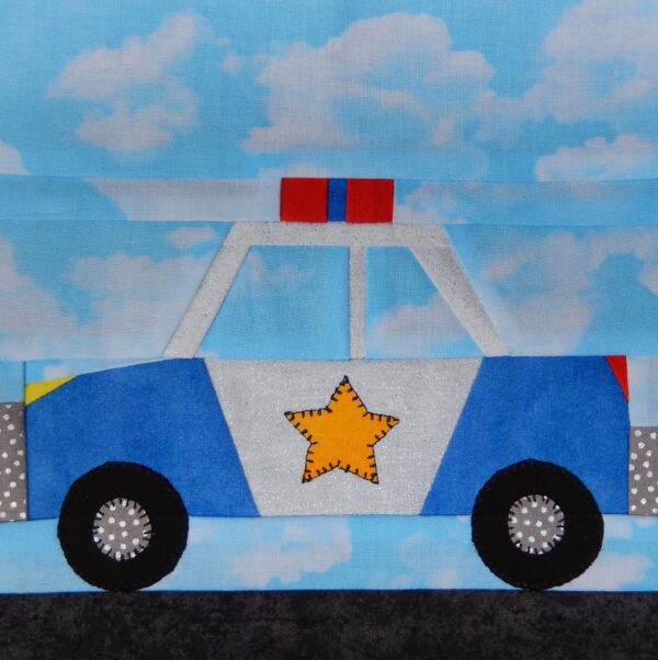 A police car quilt block with the sky in the background.