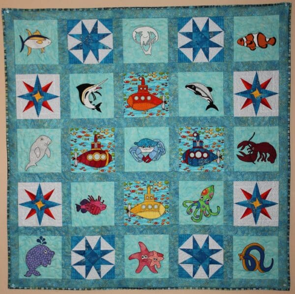 A quilt with sea animals and stars on it.