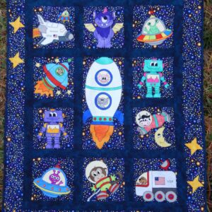 A quilt with nine different pictures of space animals.