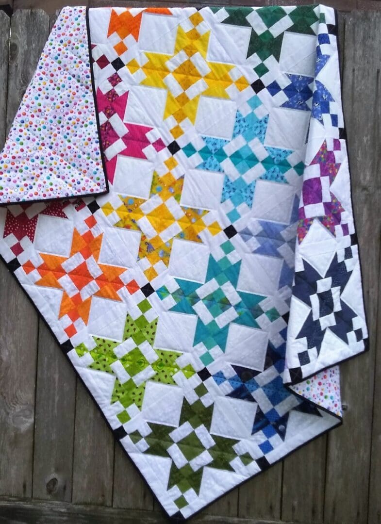 A quilt with different colored stars on it.